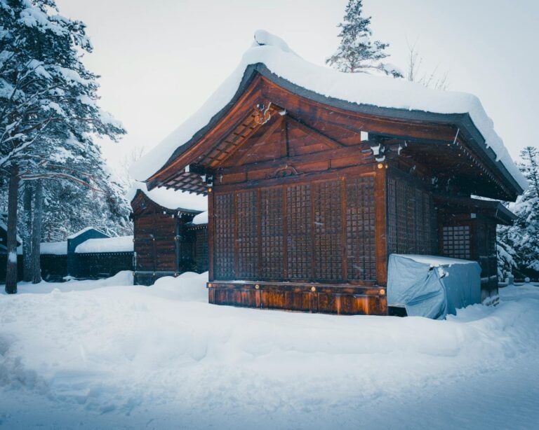 Beautiful traditional Japanese building covered in snow during winter in a serene setting.